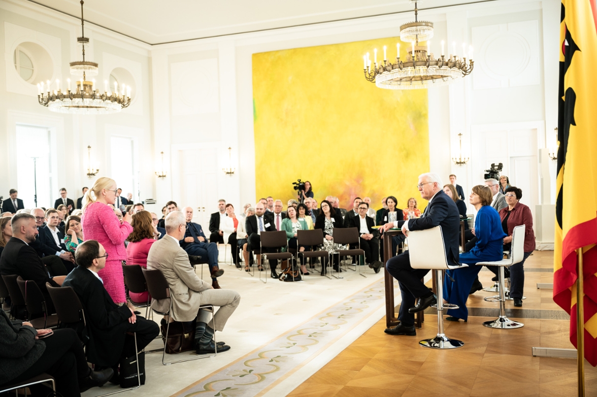 Bundespräsident Frank-Walter Steinmeier bei einer Diskussion mit einer Bürgermeisterin im Publikum der Veranstaltung