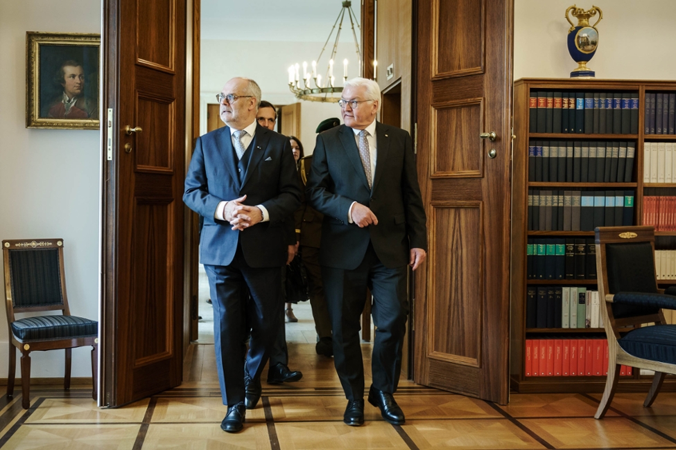 Bundespräsident Steinmeier schreitet mit dem Präsidenten der Republik Estland, Alar Karis, durch eine Flügeltür in Schloss Bellevue. Beide sind im Gespräch.
